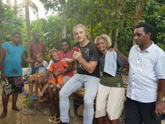Joseph Simcox bersama warga sebuah kampung di Distrik Momiwaren, ManSel, yang menyuguhi Buah Merah.