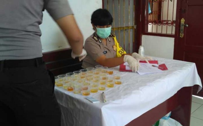 Dr. Kamarul dari Bidokes Polda Papua Barat saat memeriksa urine.